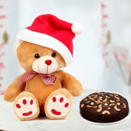 Christmas teddy bear with a red cap and chocolate cake