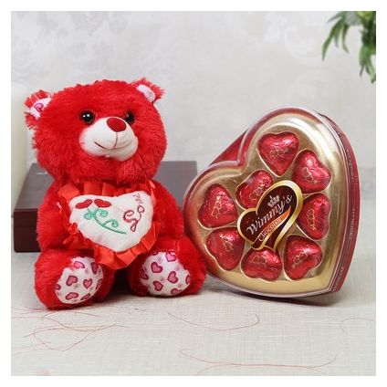 Adorable teddy with heart shape chocolate